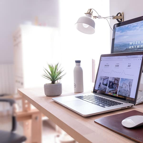 MacBook Pro on table beside white iMac and Magic Mouse